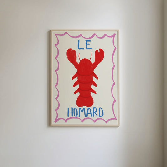 Art print featuring a hand-drawn lobster illustration with blue handwritten text 'le homard,' framed by a bold, bright pink border.