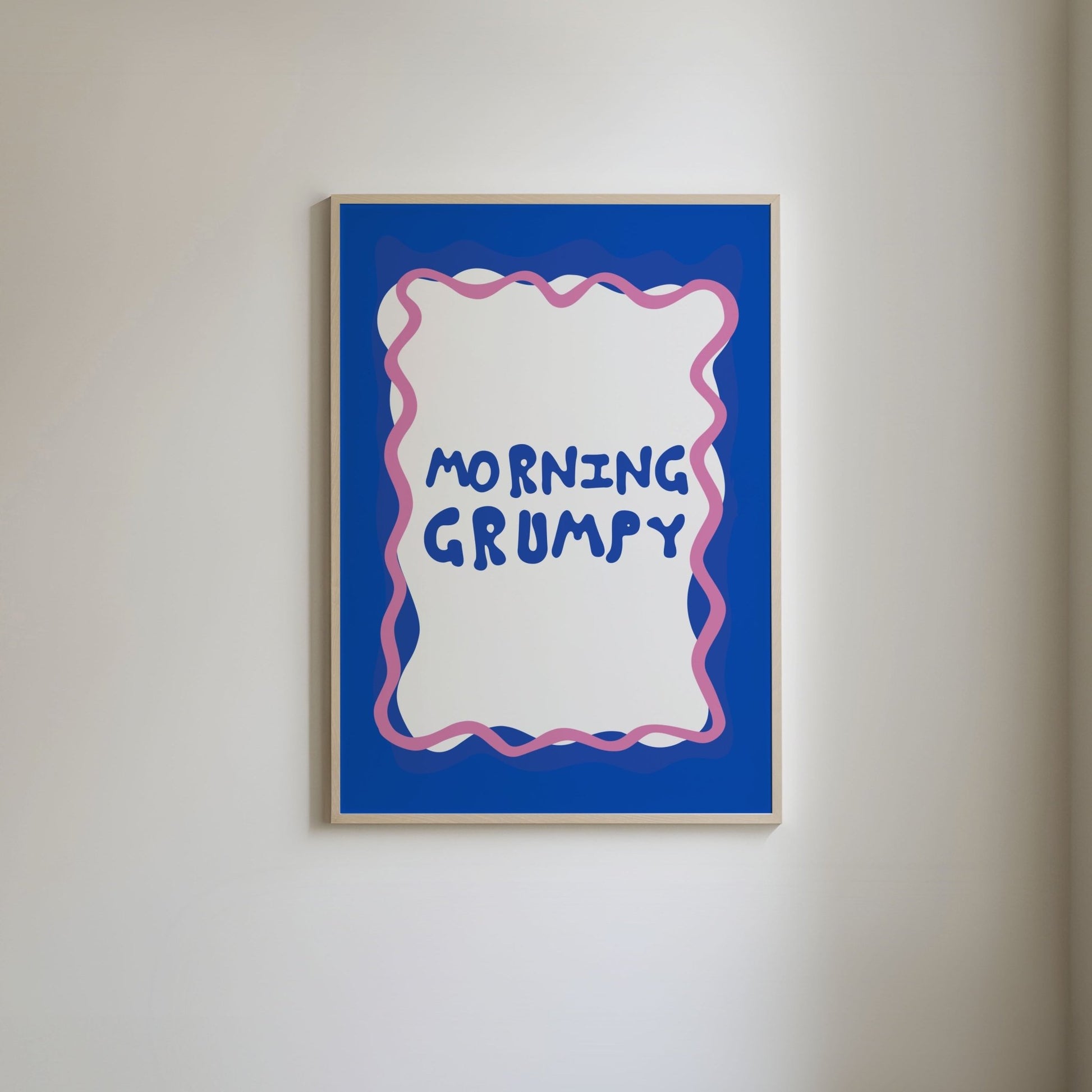 Art print with a blue border and pink squiggly line, featuring fun blue typography that reads 'Morning Grumpy.
