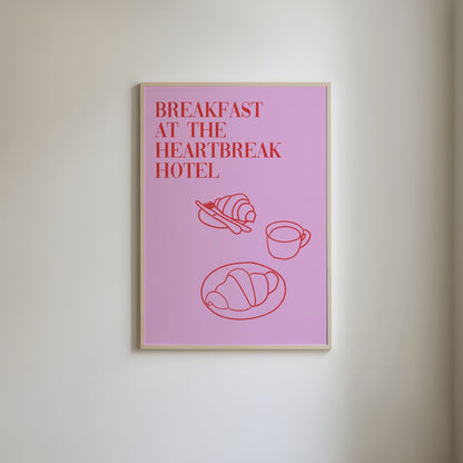 Pink background with red line art of a breakfast pastry and a cup of coffee, featuring the text 'Breakfast at the Heartbreak Hotel' in a bold, stylish font.